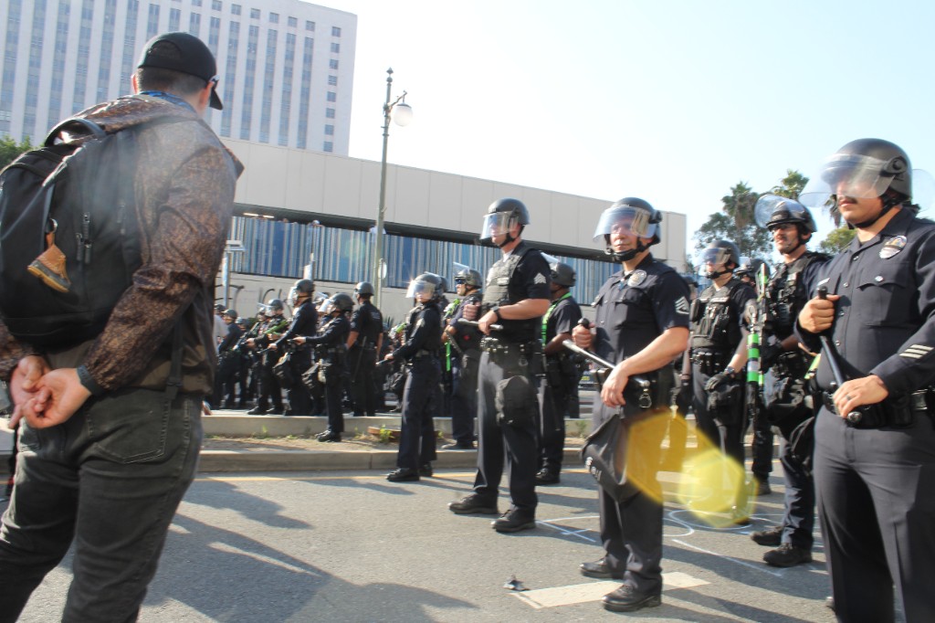 Los Angeles Police Department officers in riot gear line up facing demonstrators during a protest in downtown Los Angeles.